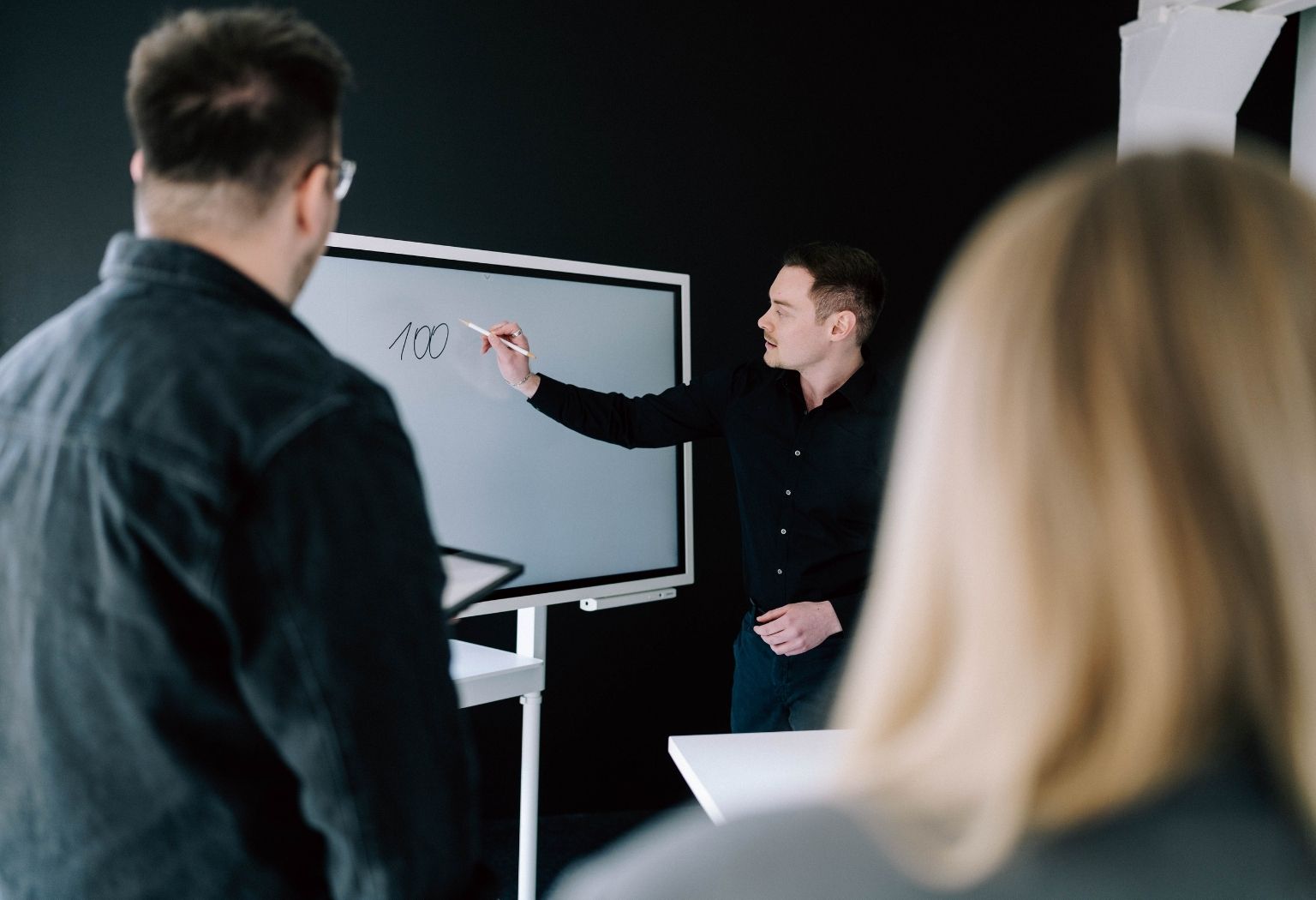 Ein Mann steht vor einem Whiteboard und präsentiert Informationen zur Suchmaschinenoptimierung.
